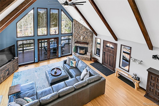1567 Tapadero Rd, Bailey, CO 80421 - living area with ceiling fan, wood finished floors, beamed ceiling, a stone fireplace, and high vaulted ceiling