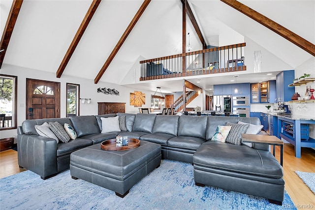 1567 Tapadero Rd, Bailey, CO 80421 - living room with high vaulted ceiling, light wood-style flooring, beam ceiling, and stairs