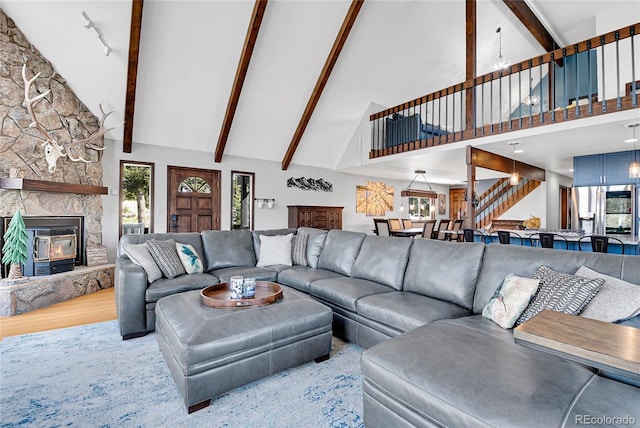 1567 Tapadero Rd, Bailey, CO 80421 - living room with high vaulted ceiling, stairway, beam ceiling, a fireplace, and wood finished floors