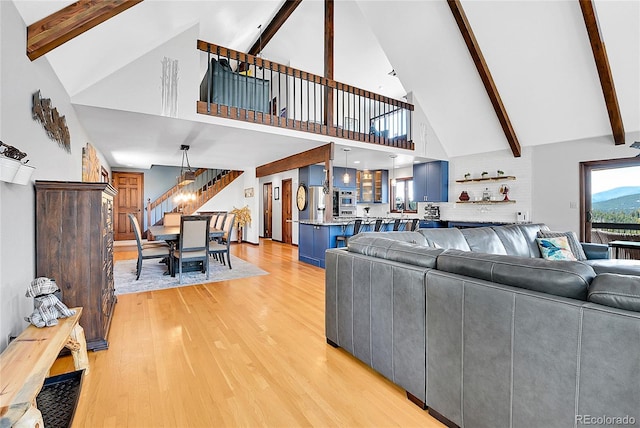 1567 Tapadero Rd, Bailey, CO 80421 - living area featuring high vaulted ceiling, light wood-style floors, beam ceiling, a chandelier, and stairway