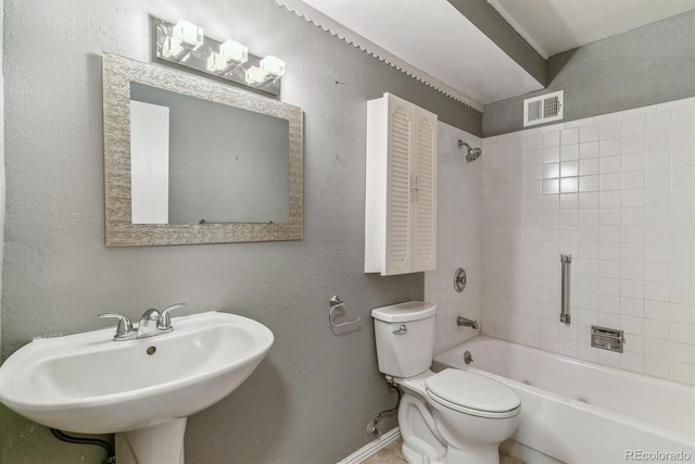 bathroom with toilet, baseboards, bathing tub / shower combination, a sink, and a textured wall