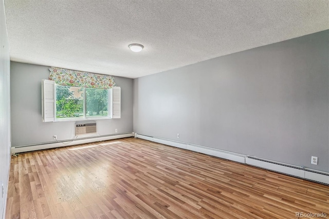 empty room featuring wood finished floors, a baseboard radiator, and a textured ceiling