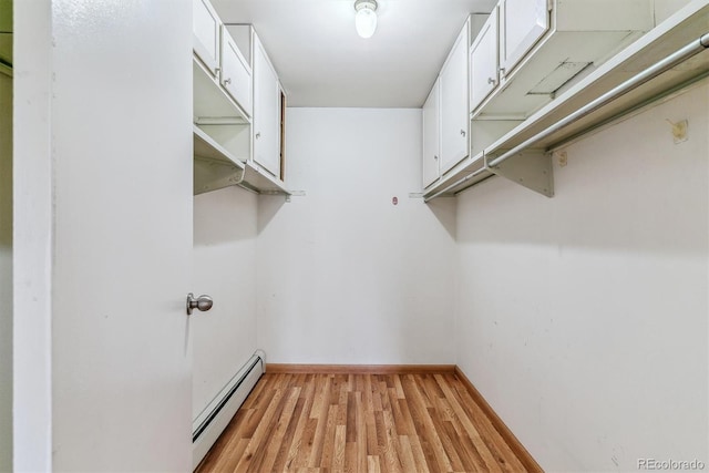 walk in closet with a baseboard radiator and light wood-style floors