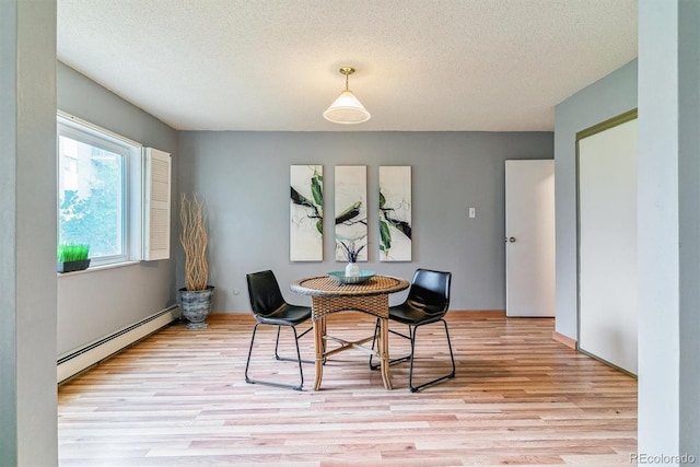 13626 E Bates Ave Unit 110, Aurora, CO 80014 - dining room with a baseboard heating unit, light wood-type flooring, and a textured ceiling