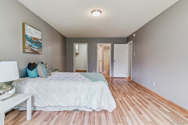 13626 E Bates Ave Unit 110, Aurora, CO 80014 - bedroom with light wood finished floors, baseboards, and ensuite bathroom