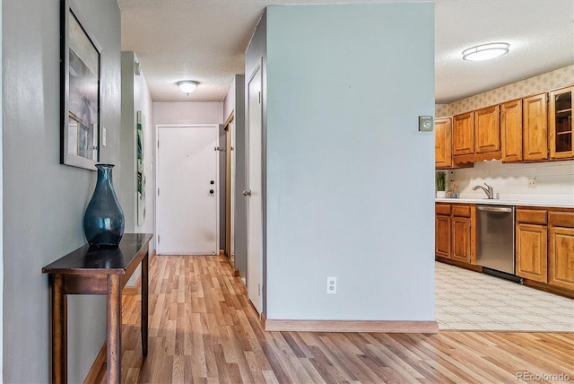 13626 E Bates Ave Unit 110, Aurora, CO 80014 - corridor with light wood-type flooring, baseboards, a textured ceiling, and a sink