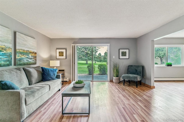 13626 E Bates Ave Unit 110, Aurora, CO 80014 - living room featuring baseboard heating, wood finished floors, a textured ceiling, a baseboard radiator, and baseboards