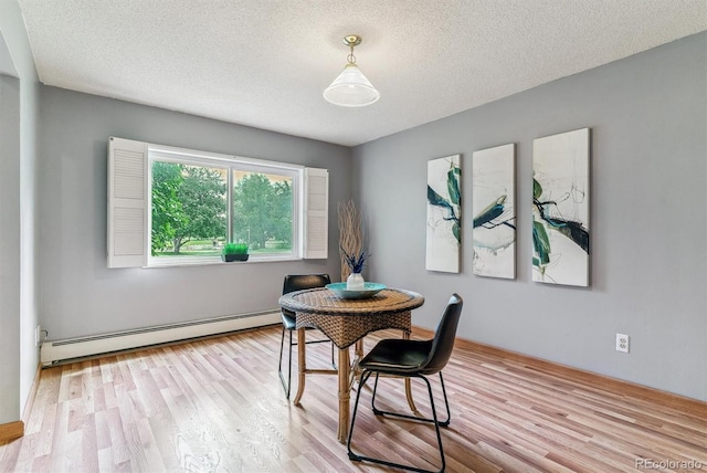 13626 E Bates Ave Unit 110, Aurora, CO 80014 - dining room with a baseboard heating unit, wood finished floors, and a textured ceiling