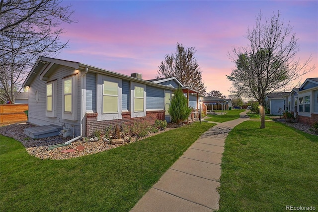 6631 E 78th Ave, Commerce City, CO 80022 - view of property exterior featuring a yard, brick siding, and fence