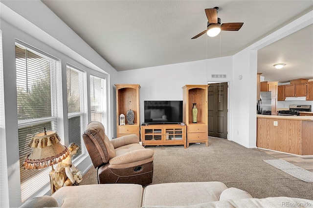 6631 E 78th Ave, Commerce City, CO 80022 - living room featuring vaulted ceiling, ceiling fan, light colored carpet, and visible vents