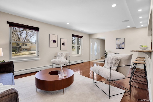 living room featuring recessed lighting, plenty of natural light, baseboards, and wood finished floors