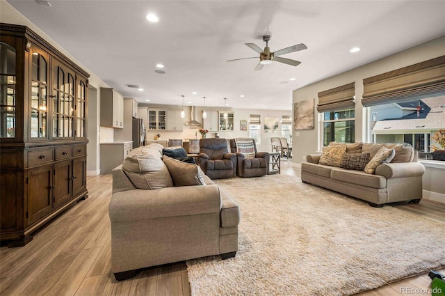 living room with ceiling fan and light wood-type flooring