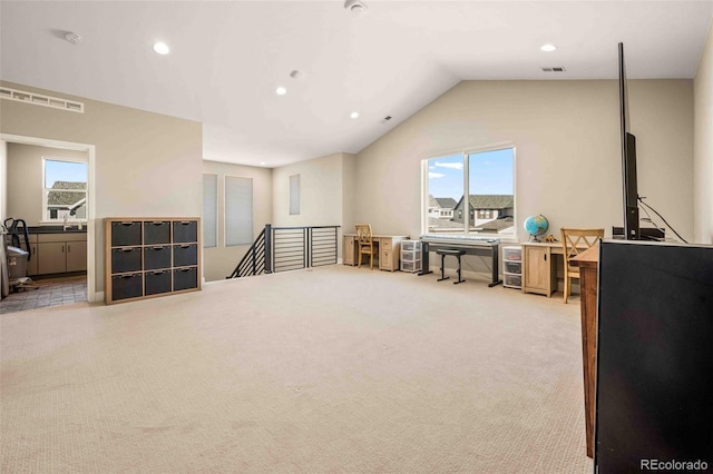 interior space with light colored carpet, vaulted ceiling, and a wealth of natural light