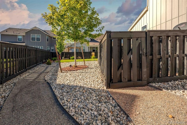 playground at dusk with a fenced backyard and a residential view