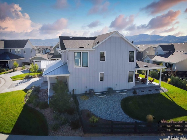 exterior space featuring a yard, a residential view, fence, and a mountain view