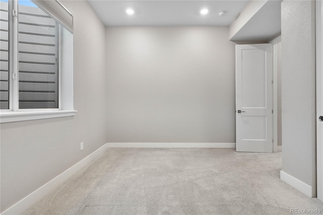 empty room featuring baseboards, recessed lighting, and light colored carpet