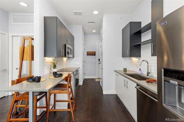 2550 Lawrence St Unit Rb306, Denver, CO 80205 - kitchen featuring appliances with stainless steel finishes, backsplash, modern cabinets, dark wood-type flooring, and recessed lighting