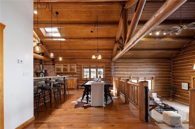 29095 Summit Ranch Dr, Golden, CO 80401 - dining space featuring log walls, wood ceiling, light wood-type flooring, high vaulted ceiling, and a wood stove