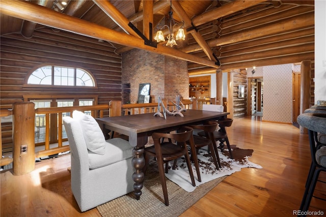 29095 Summit Ranch Dr, Golden, CO 80401 - dining room with log walls, a chandelier, light wood-style floors, high vaulted ceiling, and wooden ceiling with exposed beams