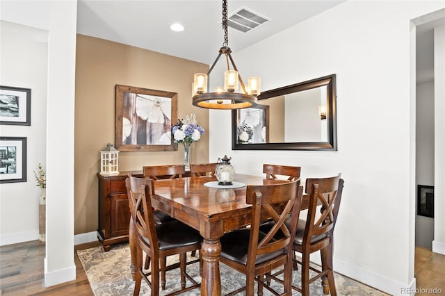 dining room featuring hardwood / wood-style floors and an inviting chandelier