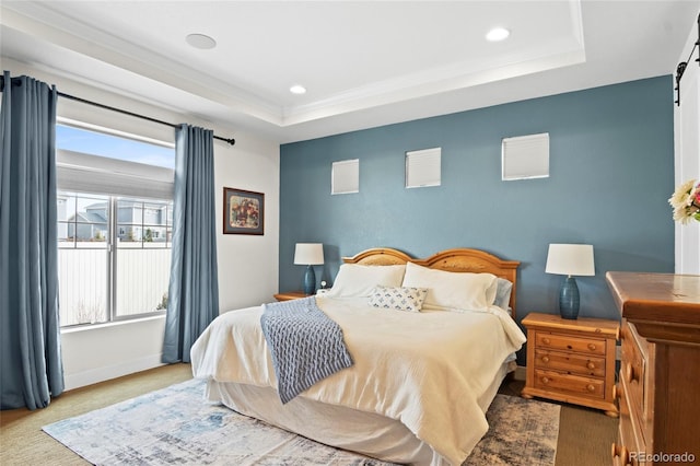 bedroom featuring ornamental molding, a barn door, and a raised ceiling