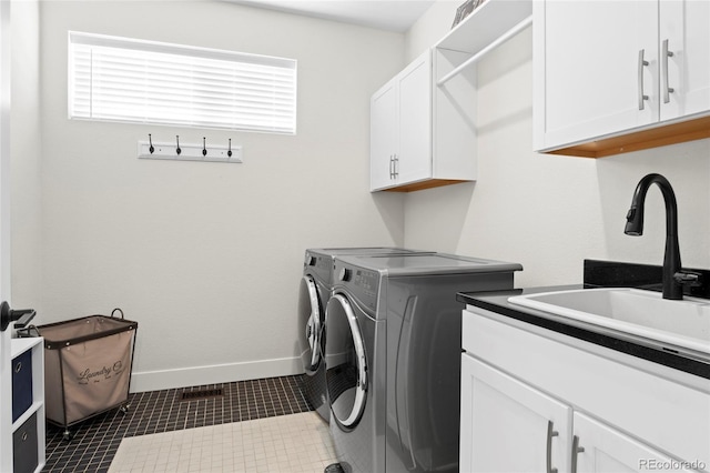 washroom featuring cabinets, dark tile patterned flooring, sink, and washing machine and clothes dryer