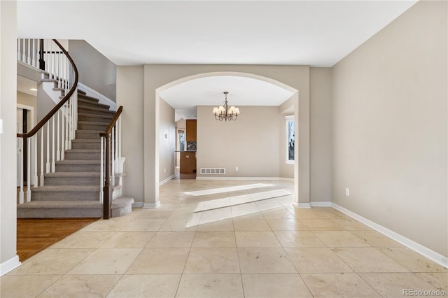 foyer entrance featuring light tile patterned floors and an inviting chandelier