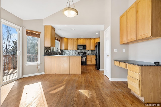 kitchen featuring sink, hanging light fixtures, kitchen peninsula, black appliances, and light wood-type flooring