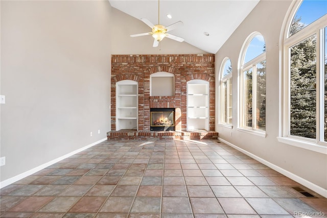 unfurnished living room with tile patterned flooring, ceiling fan, a fireplace, and high vaulted ceiling