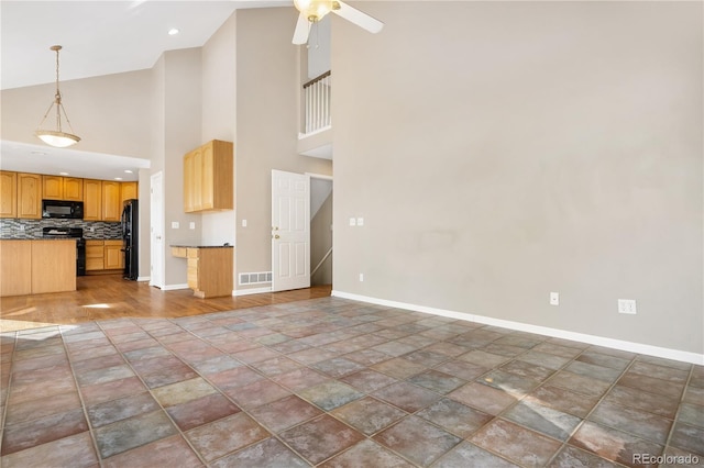 interior space with ceiling fan and a high ceiling