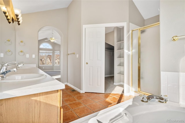 bathroom with tile patterned flooring, vanity, vaulted ceiling, and ceiling fan