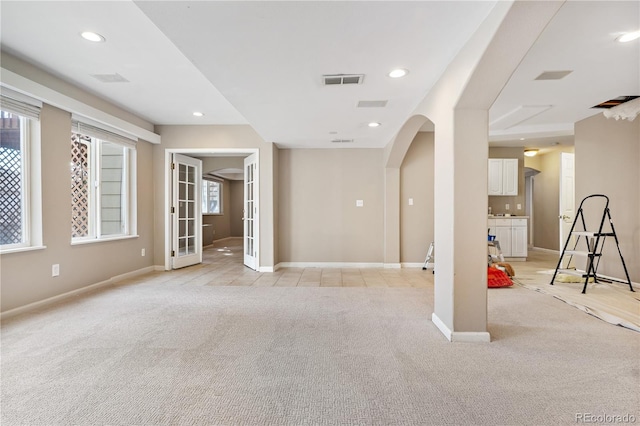 carpeted empty room with plenty of natural light and french doors