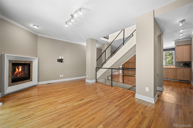 1635 N Franklin St, Denver, CO 80218 - unfurnished living room with ornamental molding, light wood-style floors, baseboards, a glass covered fireplace, and stairs
