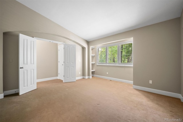1635 N Franklin St, Denver, CO 80218 - unfurnished bedroom featuring carpet flooring, baseboards, arched walkways, and lofted ceiling