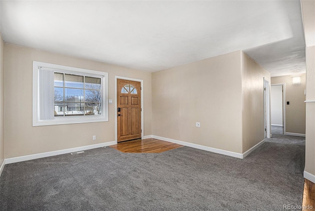 carpeted entryway featuring visible vents and baseboards