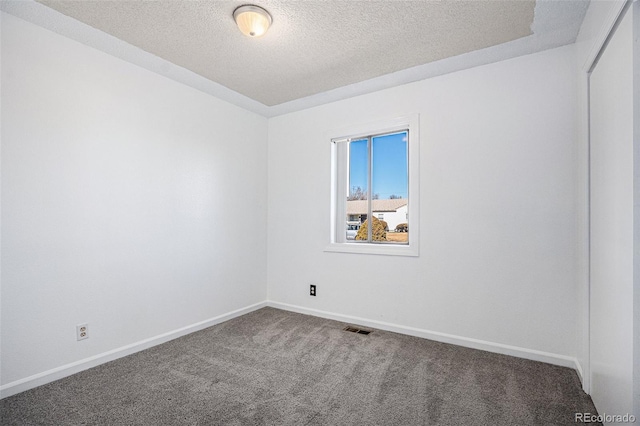 unfurnished room with baseboards, visible vents, a textured ceiling, and carpet flooring