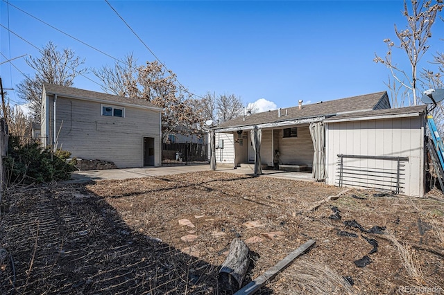 rear view of house featuring a patio and fence