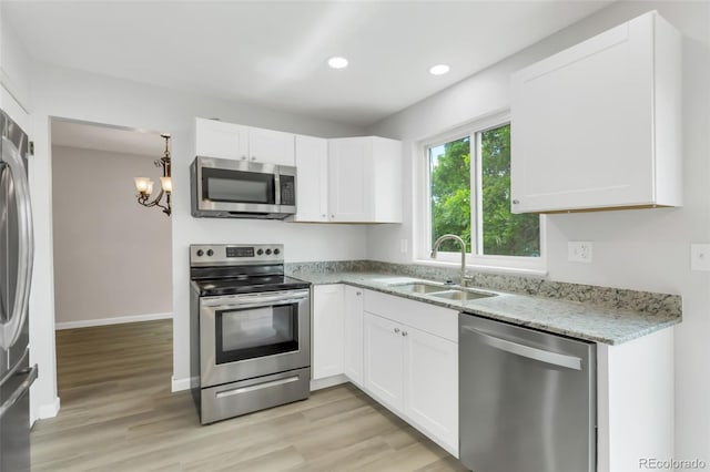 1005 S Lewiston Way, Aurora, CO 80017 - kitchen featuring appliances with stainless steel finishes, a sink, white cabinets, light wood-style floors, and recessed lighting