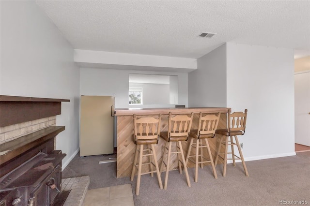 1005 S Lewiston Way, Aurora, CO 80017 - dining area with a bar, carpet floors, a textured ceiling, and baseboards