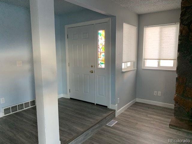 entrance foyer featuring dark wood-type flooring and a textured ceiling