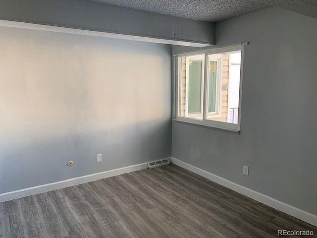 unfurnished room with dark hardwood / wood-style flooring and a textured ceiling