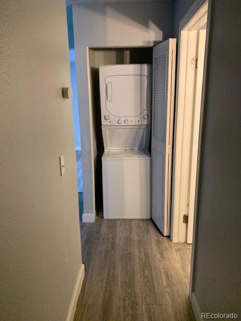 laundry area featuring stacked washer and dryer and hardwood / wood-style floors