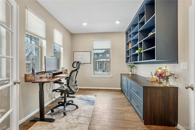 home office with plenty of natural light and light wood-type flooring