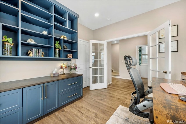 office with french doors and light hardwood / wood-style floors