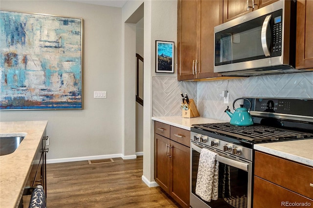 kitchen featuring tasteful backsplash, stainless steel appliances, and dark hardwood / wood-style flooring