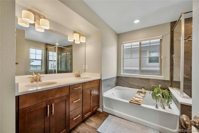 bathroom featuring hardwood / wood-style flooring, vanity, and plus walk in shower