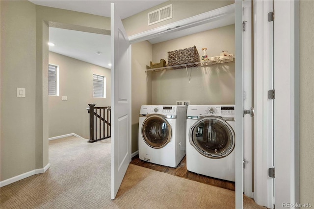 clothes washing area with light colored carpet and washing machine and clothes dryer