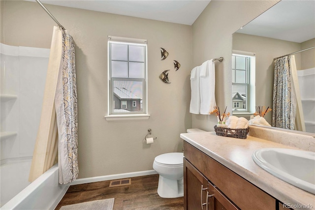 full bathroom featuring hardwood / wood-style flooring, vanity, shower / bath combo, and toilet