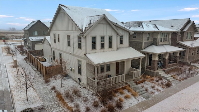 snow covered house featuring a porch