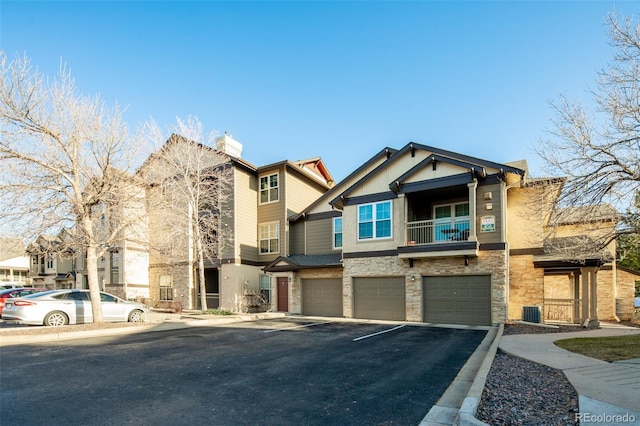 view of front of property featuring stone siding, stucco siding, driveway, and a garage